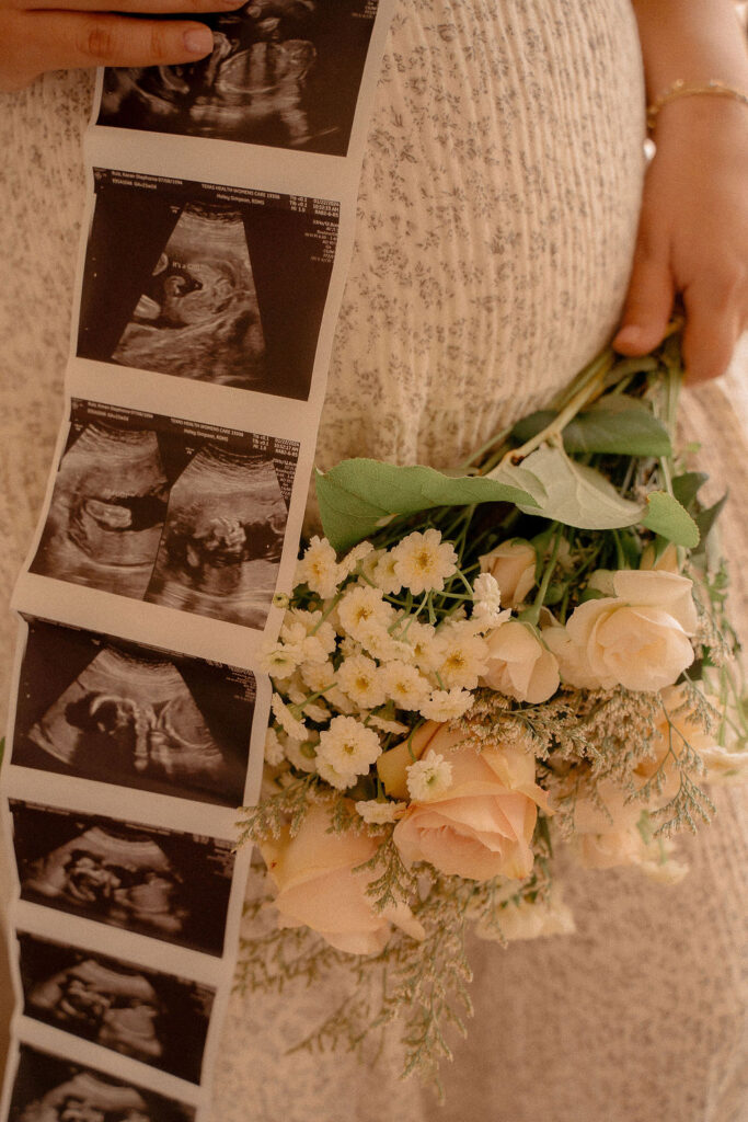 Mom holding sonogram and beautiful bouquet of flowers by pregnant belly